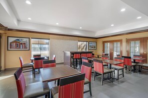 A spacious dining area with multiple tables and chairs, a reception desk, and framed pictures on the walls. - Comfort Inn & Suites Spartanburg North (Spartanburg)