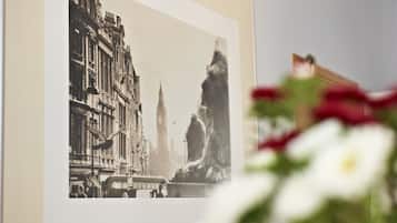 Fotografía en blanco y negro enmarcada que muestra un paisaje urbano con edificios y una estatua.
