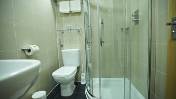 A modern bathroom with a toilet, sink, and glass-enclosed shower.
