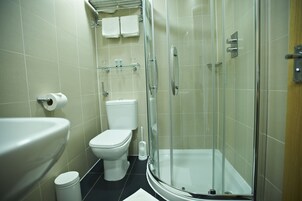 Ein modernes Badezimmer mit Toilette, Waschbecken und einer Duschkabine.