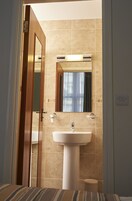 A bathroom with a sink, mirror, and toilet.