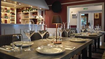 Un restaurant doté d’un bar, de tables et de chaises en bois.