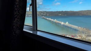 Vista de un muelle que se adentra en el agua, bajo un cielo despejado.