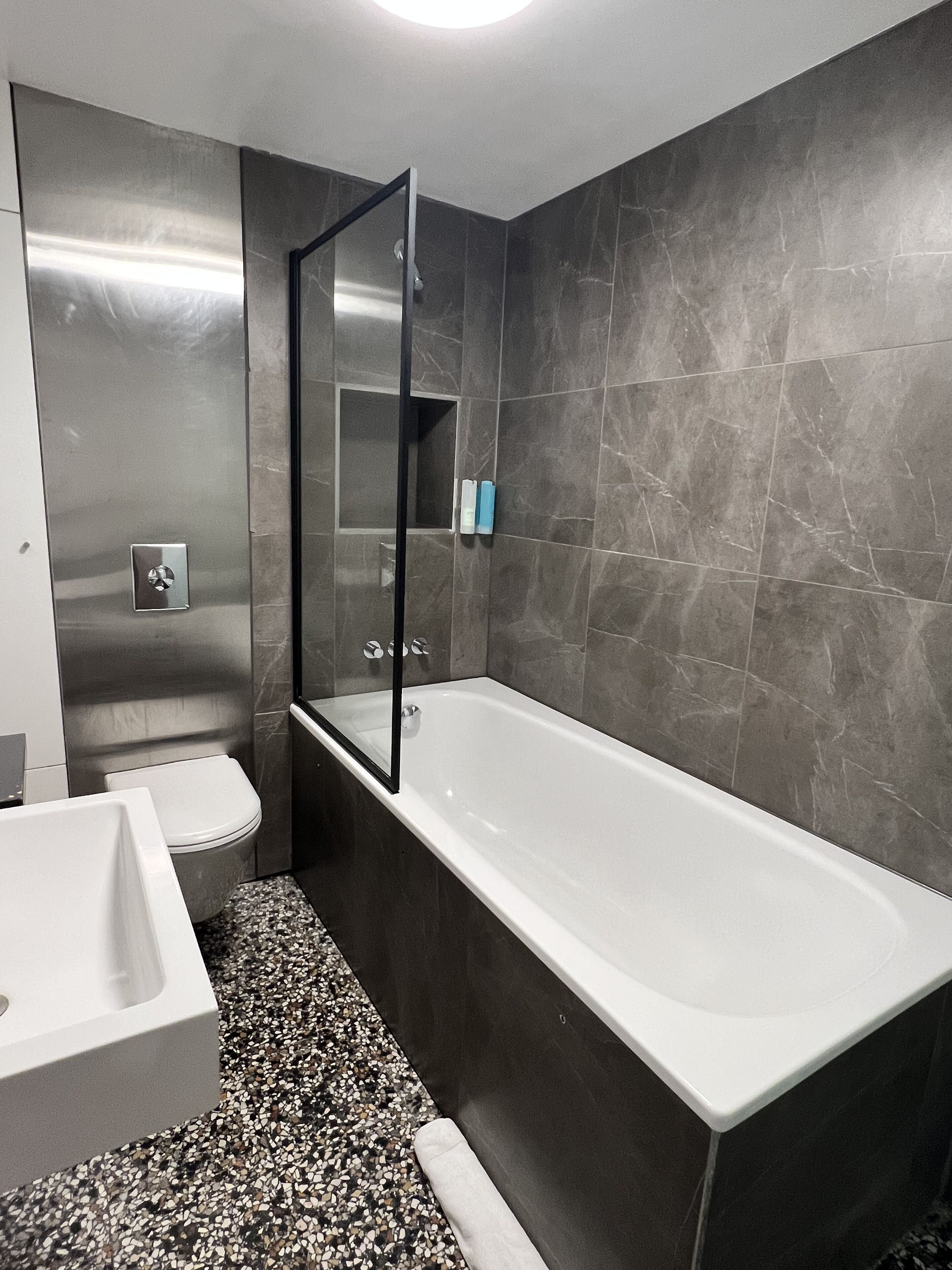 A modern bathroom with a bathtub, toilet, and sink.