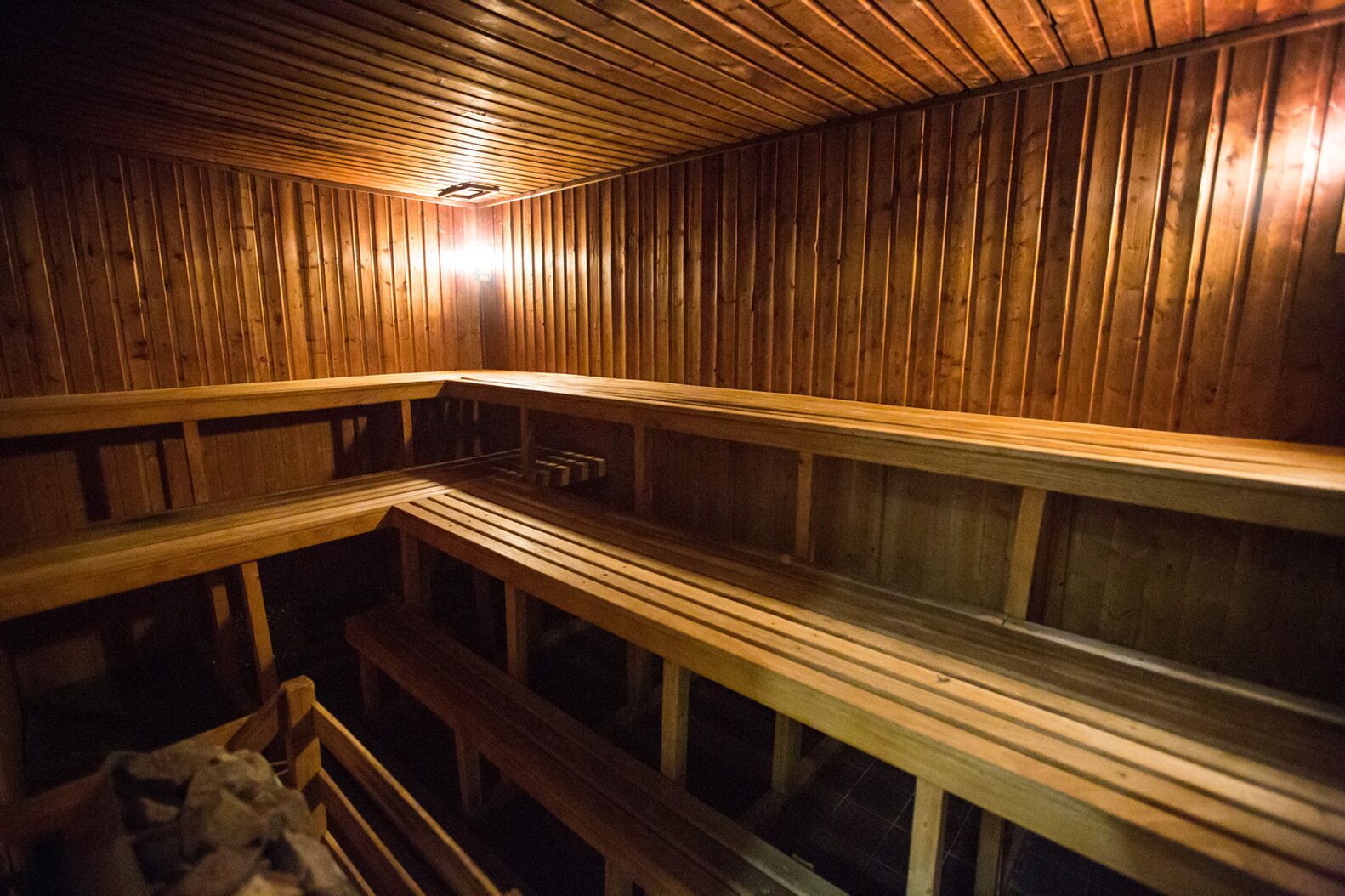 A sauna with wooden benches and a sloped ceiling.