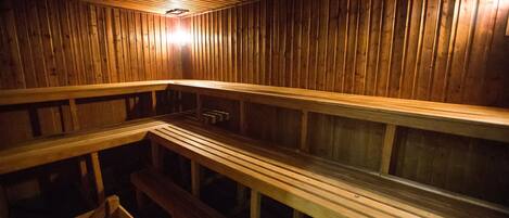 A sauna with wooden benches and a sloped ceiling.