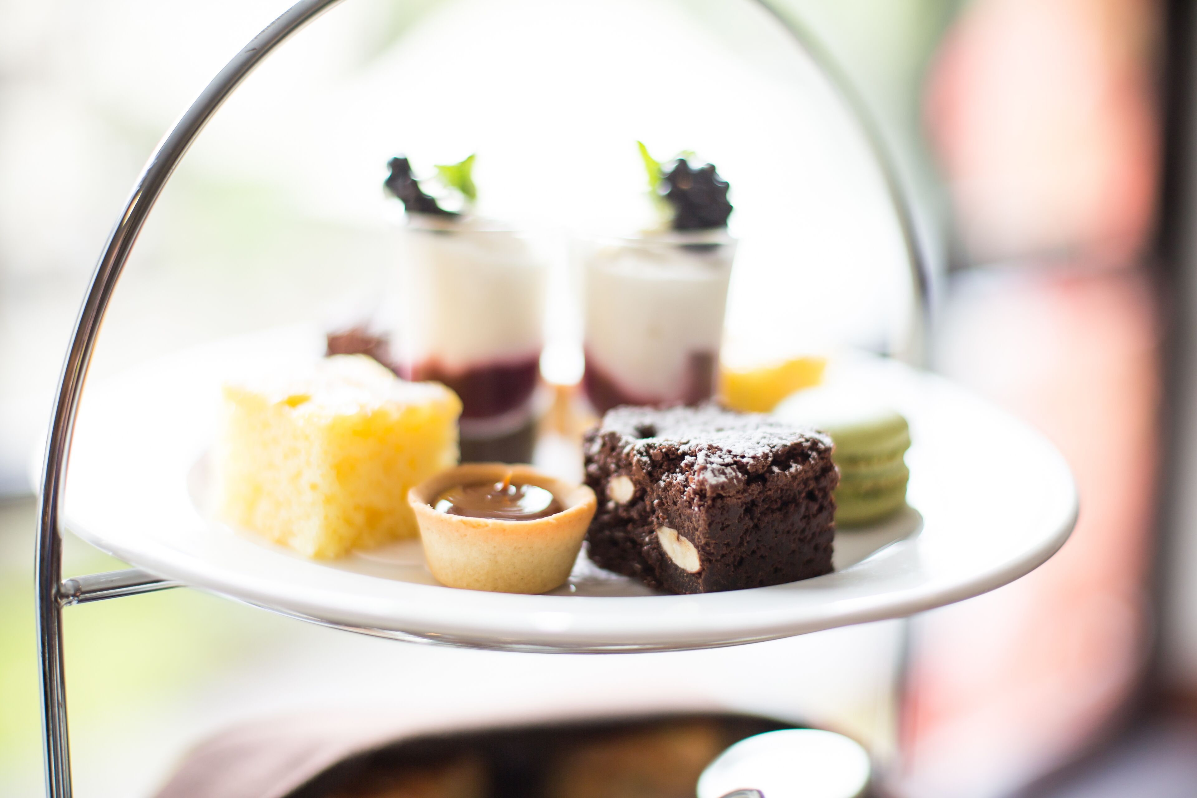 A dessert tray with various sweets, including a tart, a chocolate dessert, and a small tart with a dollop of cream.