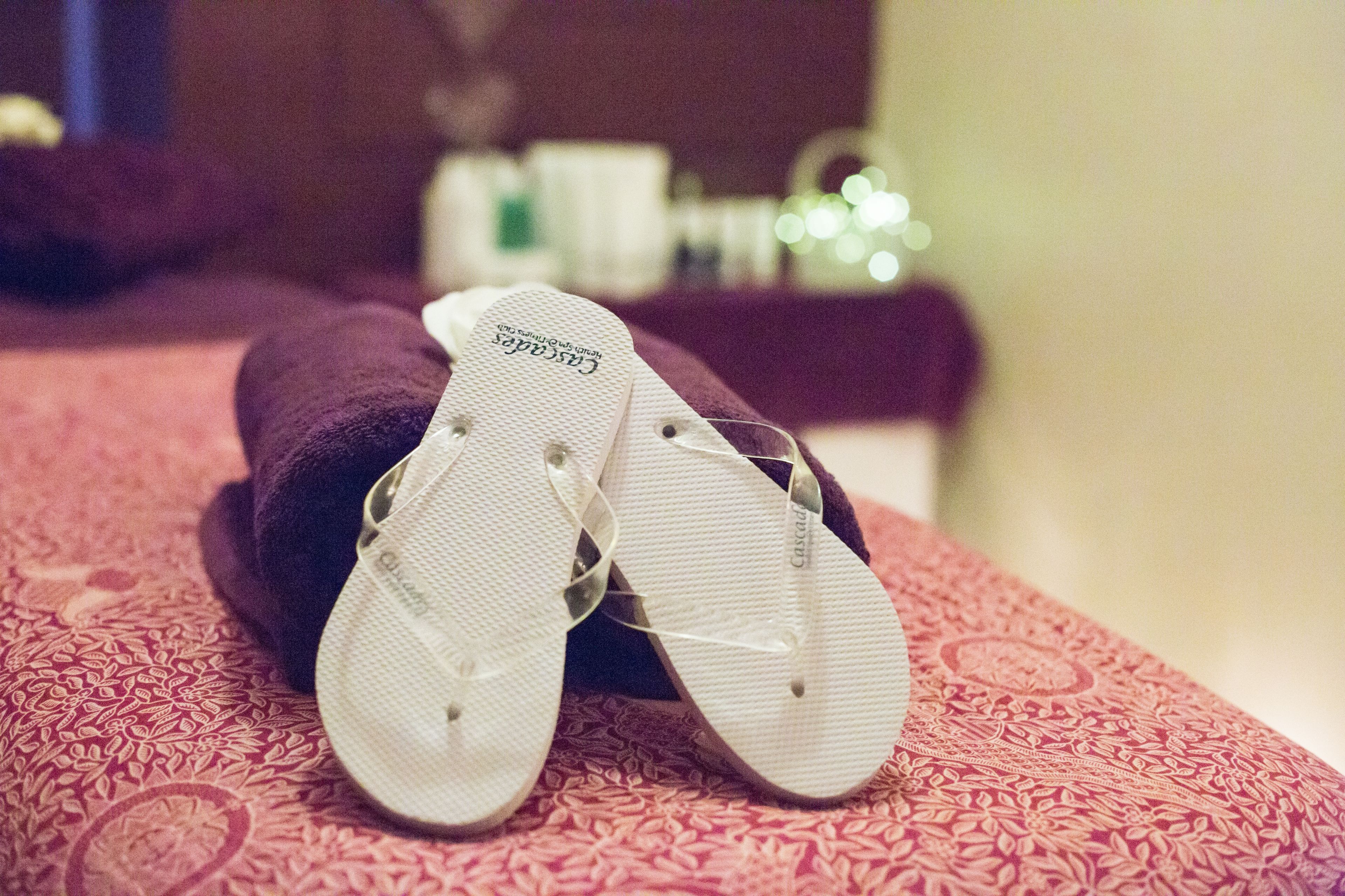 Un par de chanclas sobre una colcha estampada.