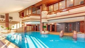 An indoor swimming pool with a high ceiling, wooden beams, and a modern design. - Whitewater Spa & Leisure Club (Ulverston)