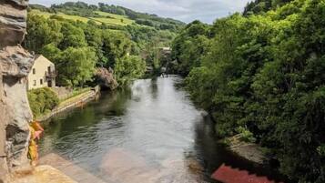 A river with a stone bridge and a building on the left.
