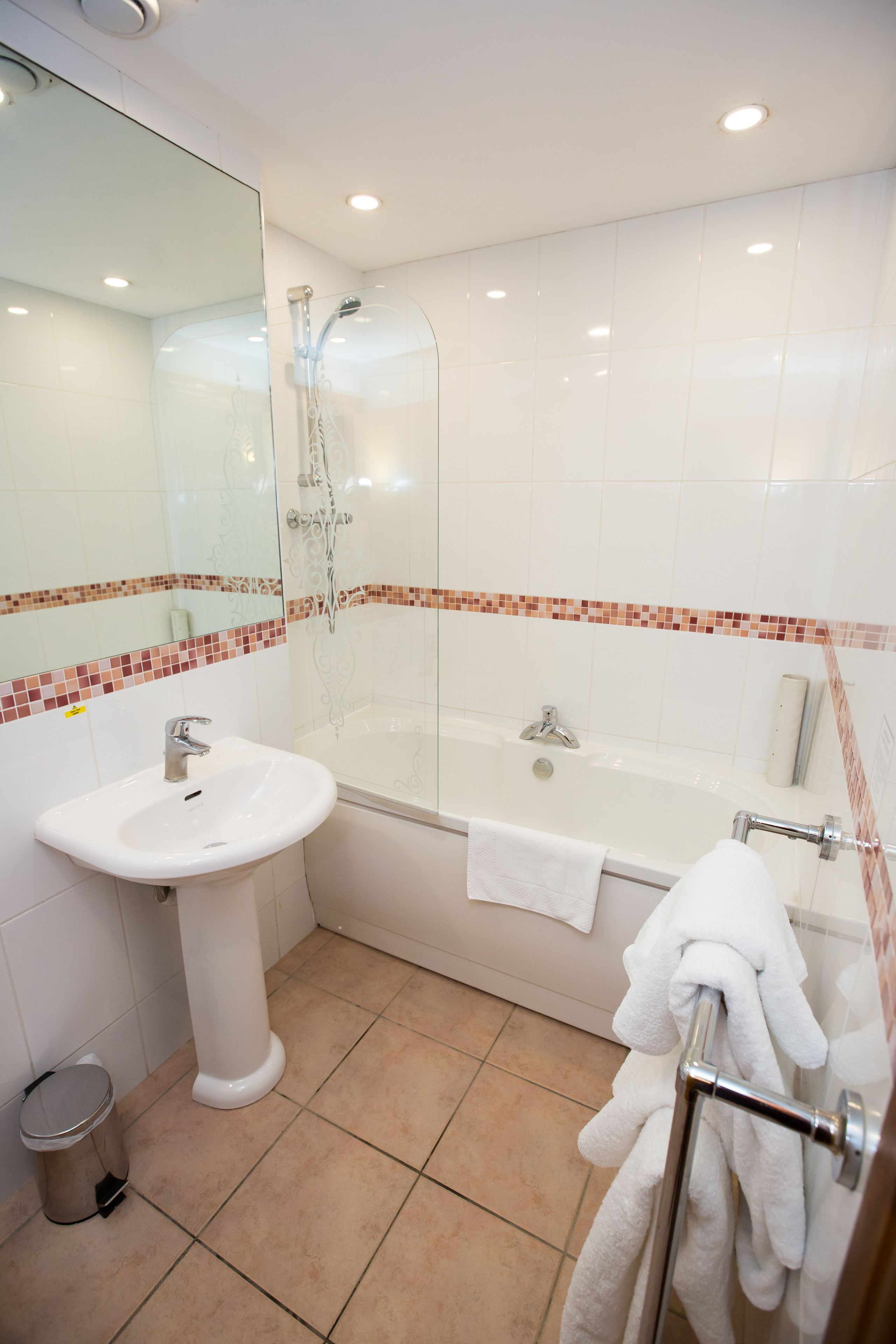 Ein Badezimmer mit Waschbecken, Duschkabine aus Glas und Badewanne.