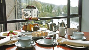 A table set for afternoon tea with a scenic view of a river and buildings. - Whitewater Spa & Leisure Club (Ulverston)