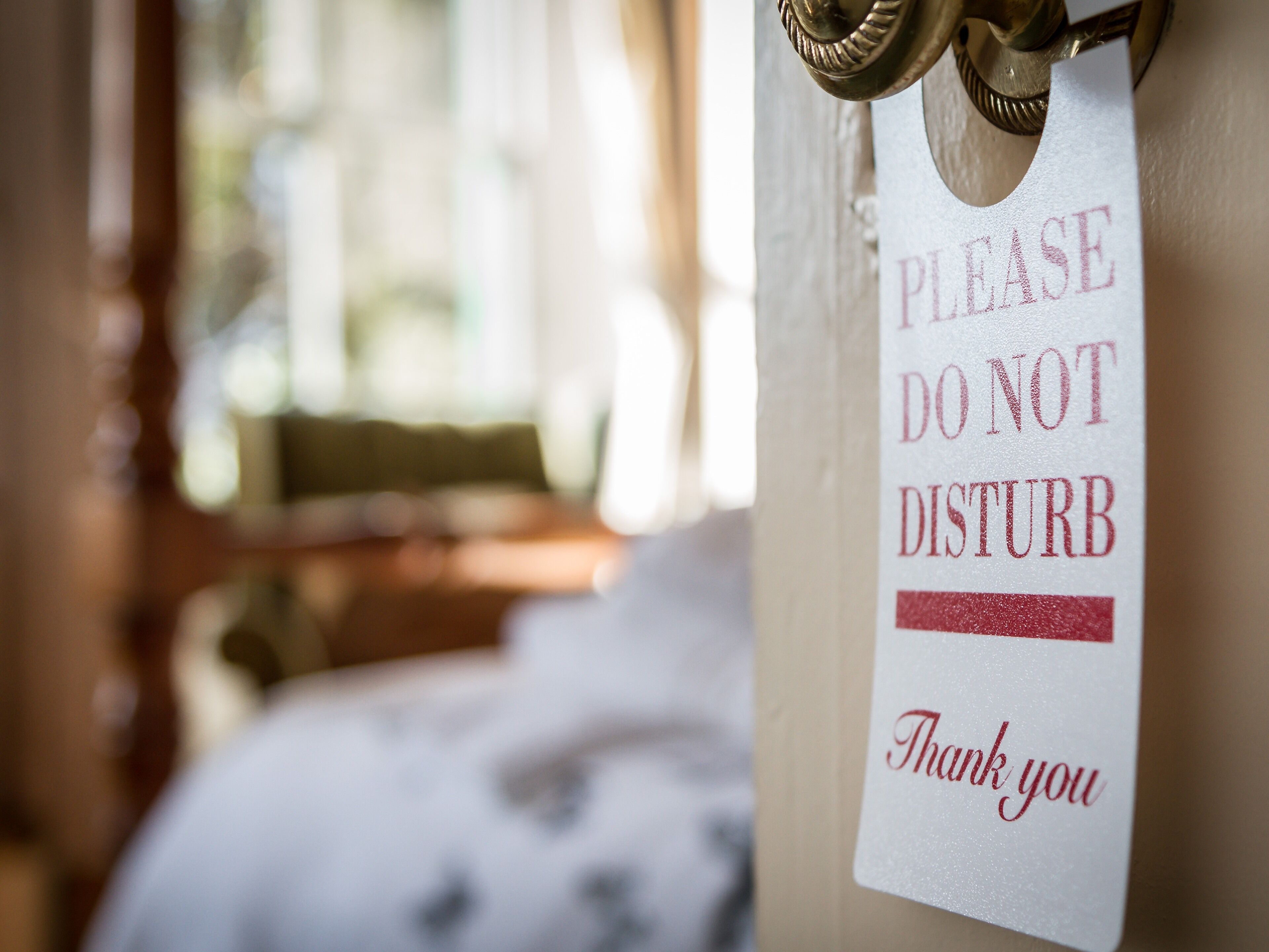 Eine Hotelzimmertür mit einem Schild, auf dem steht: "BITTE NICHT STÖREN. Vielen Dank."
