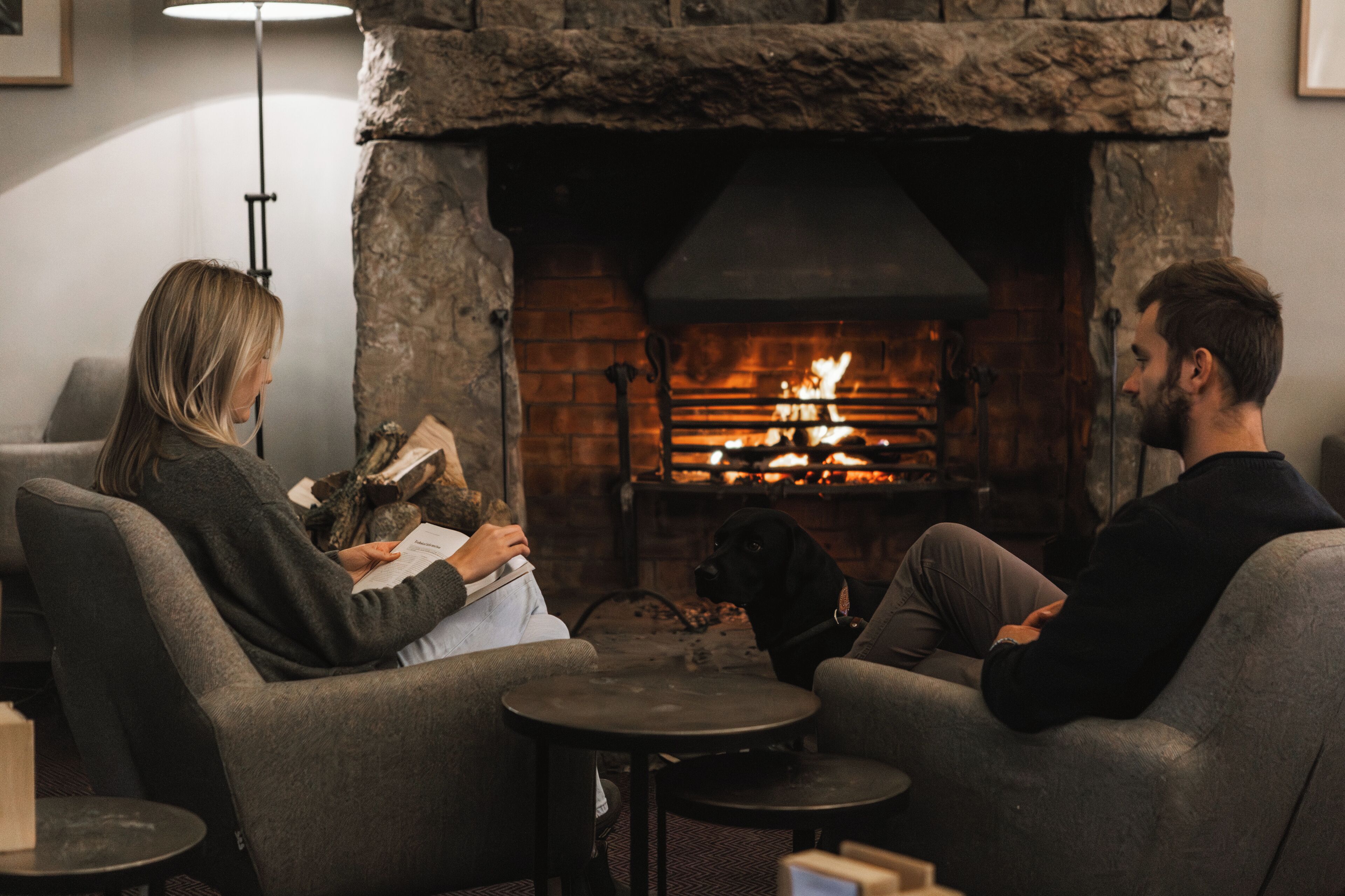 Una habitación acogedora con chimenea de piedra, dos sofás y una mesita.