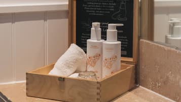 Une boîte en bois contenant des articles de toilette, posée sur le comptoir d’une salle de bain.