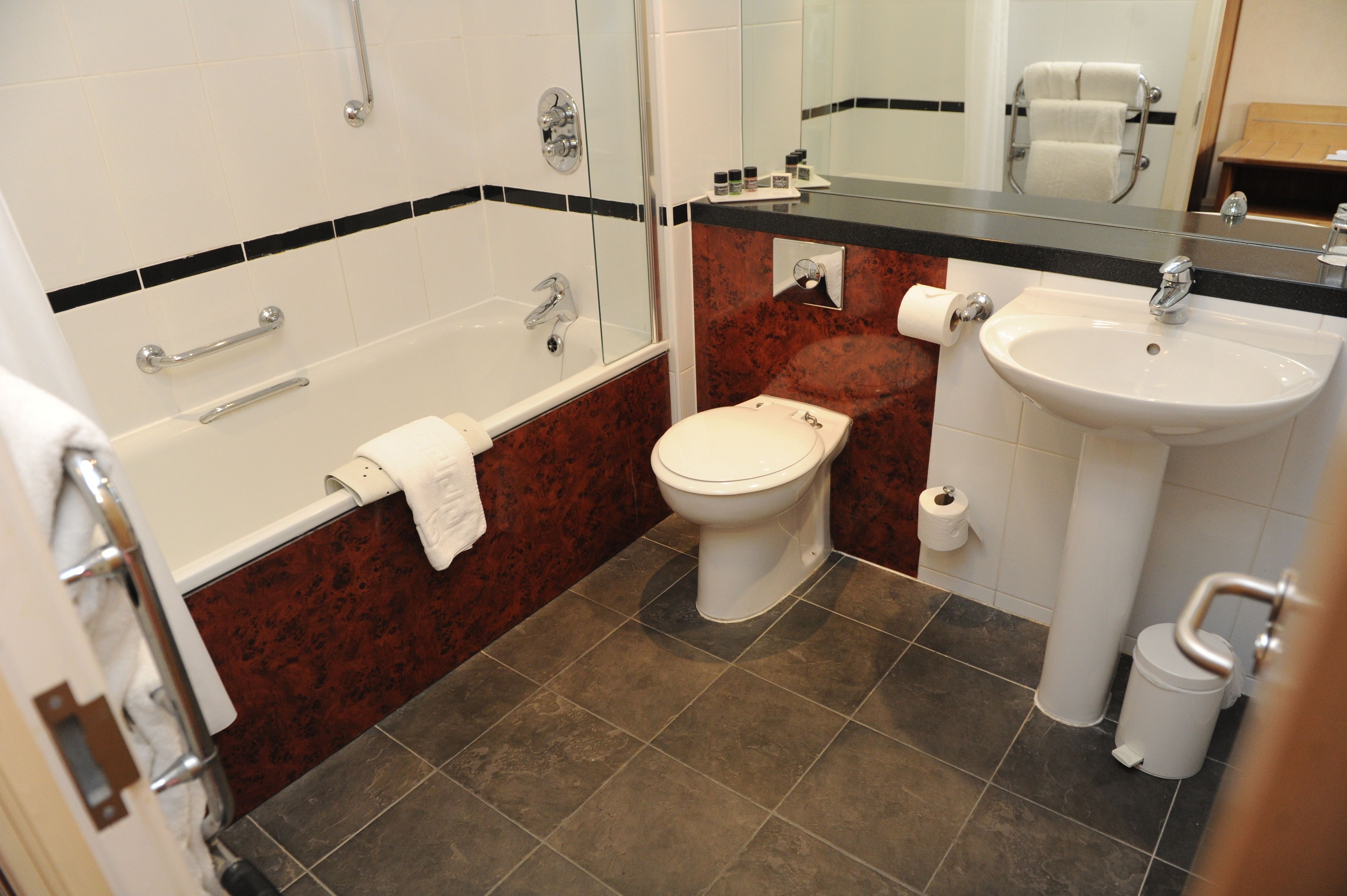 A bathroom with a bathtub, toilet, and sink.