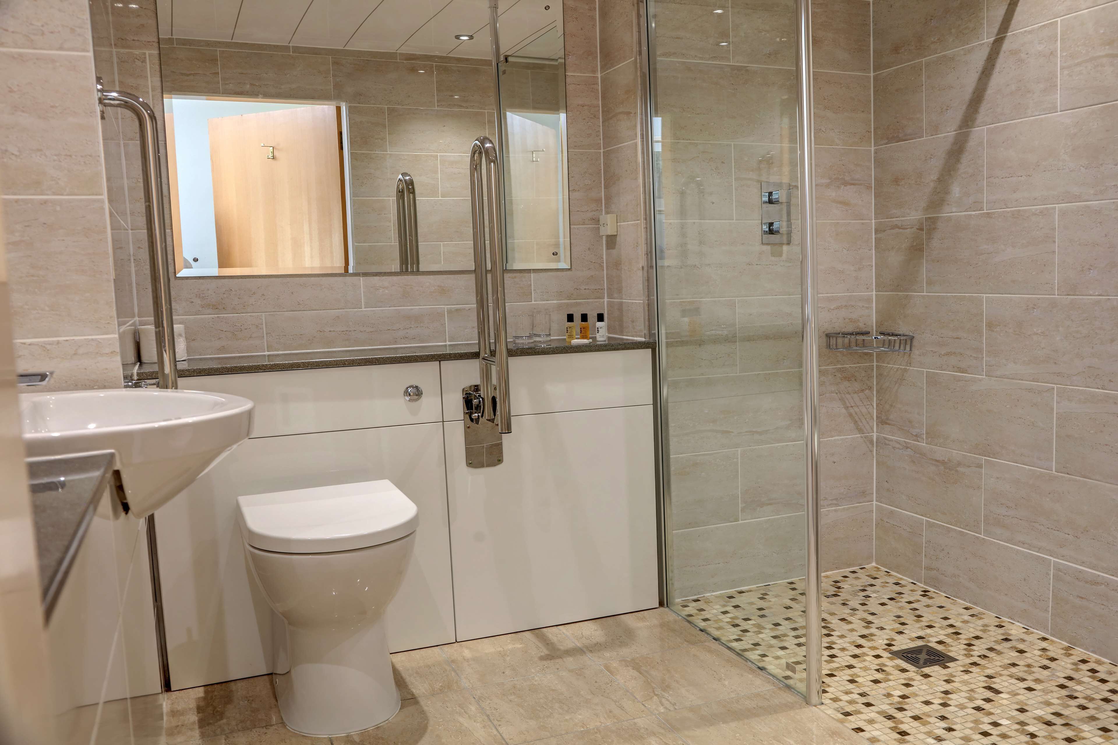 Une salle de bain moderne avec une douche à parois de verre, un lavabo blanc et des toilettes.