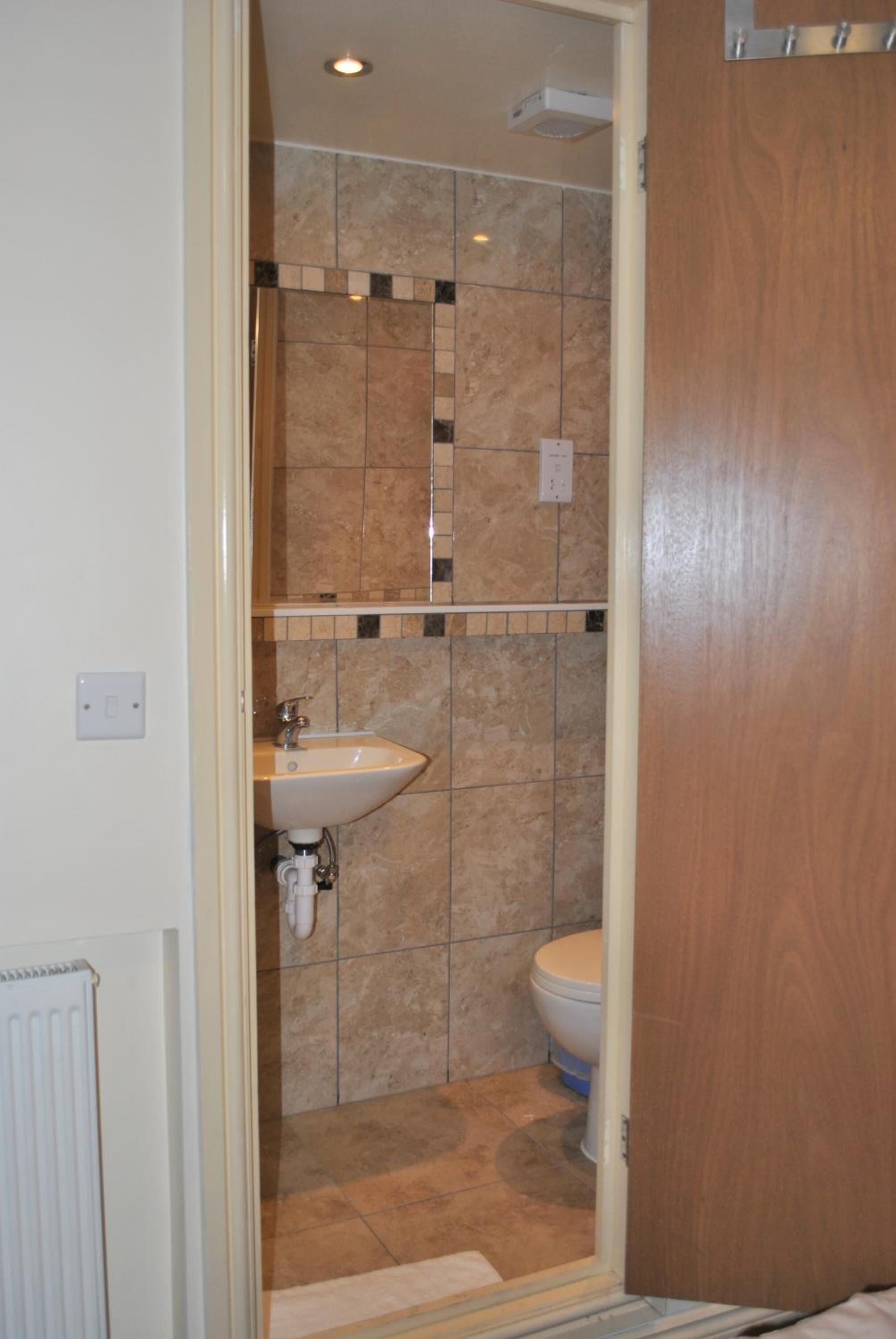 A bathroom with a sink, toilet, and shower area.