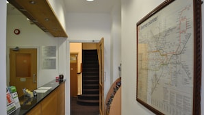 Un pasillo con mostrador de recepción, una escalera y un gran mapa en la pared.