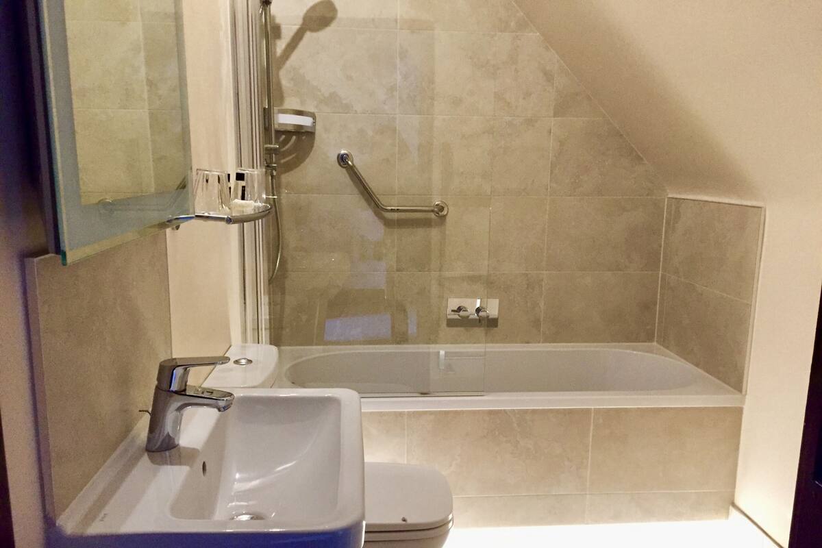 Een badkamer met een wastafel, toilet en bad.