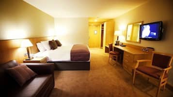 Une chambre d’hôtel équipée d’un lit, d’un bureau, d’une chaise et d’un téléviseur.