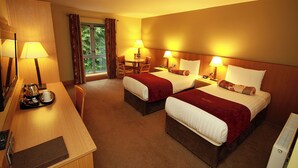 A hotel room with two beds, a desk with a coffee maker, and a window with curtains. - Belmore Court & Motel (Enniskillen)
