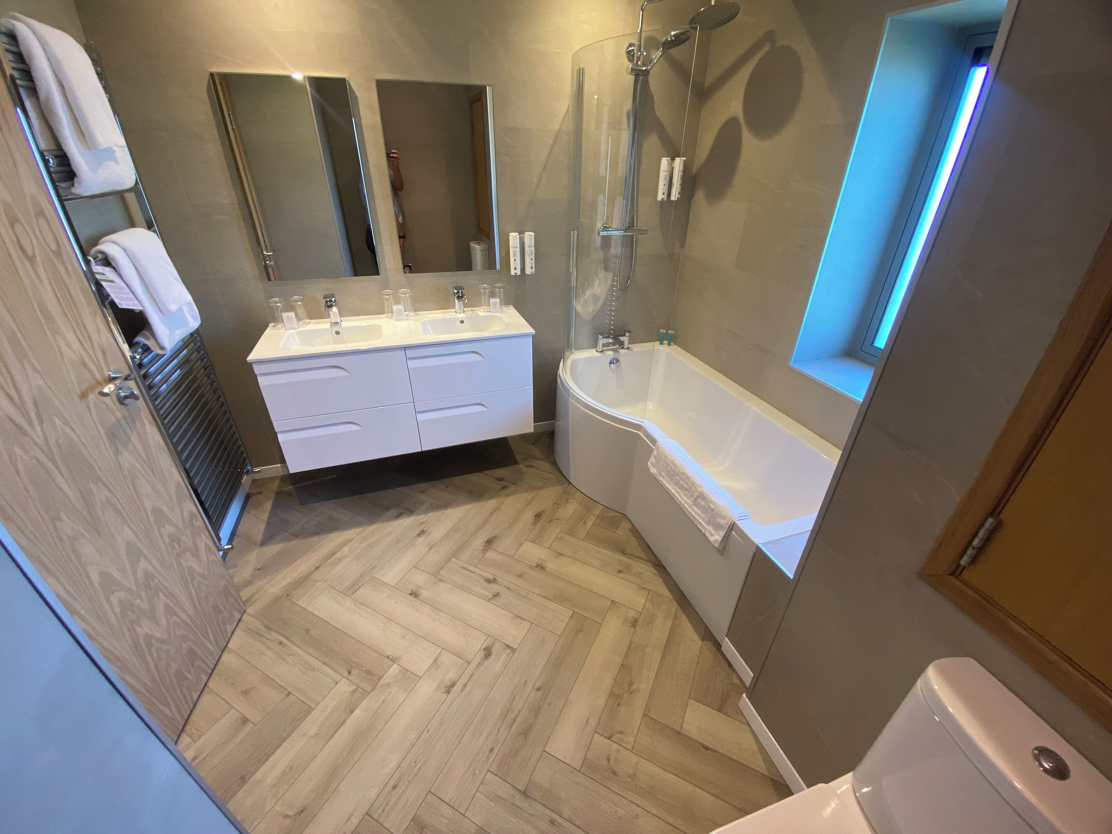 A modern bathroom with a double sink vanity, a freestanding bathtub, and a walk-in shower.