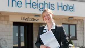 Une enseigne d’hôtel indiquant « The Heights Hotel » et, en dessous, une autre enseigne avec le mot « Bienvenue ».