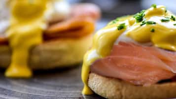 A close-up of a breakfast dish with eggs, smoked salmon, and hollandaise sauce.