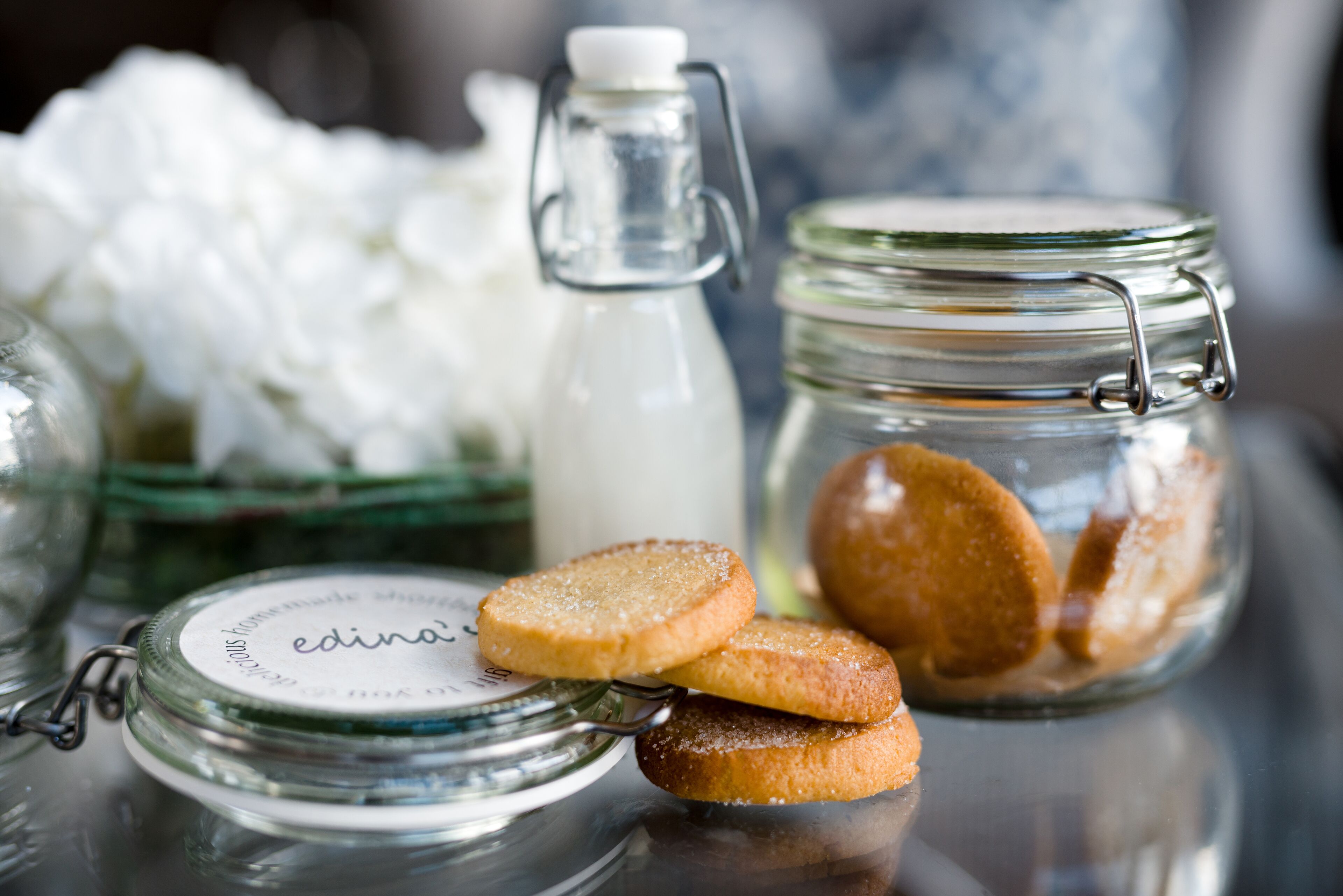 A glass jar with a metal clasp lid, a glass bottle with a metal cap, and a glass container with a metal clasp lid.