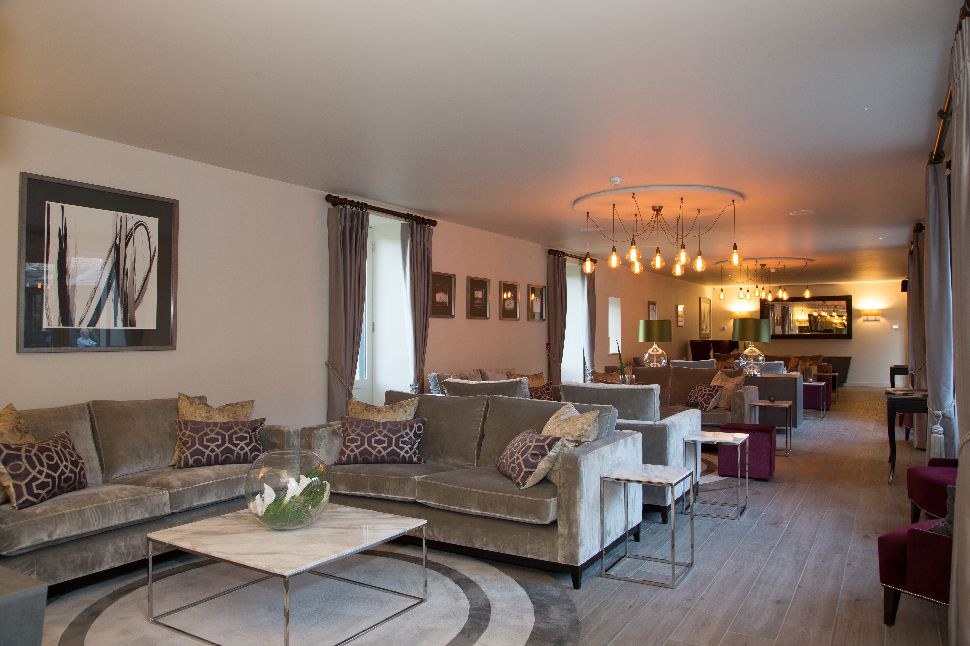 A modern living room with a sectional sofa, a coffee table, and a dining area in the background.