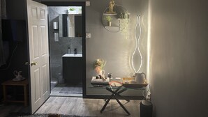 Un baño moderno con un lavabo blanco, un espejo y una planta pequeña.