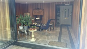 Un interior moderno con un comedor que incluye una mesa, sillas, plantas en macetas y un jarrón decorativo.