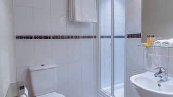 A modern bathroom with a toilet, shower, and sink.