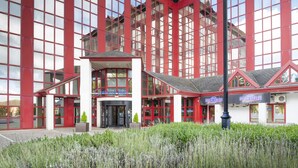 Un hotel moderno con fachada roja y blanca, ventanas amplias y una entrada central.