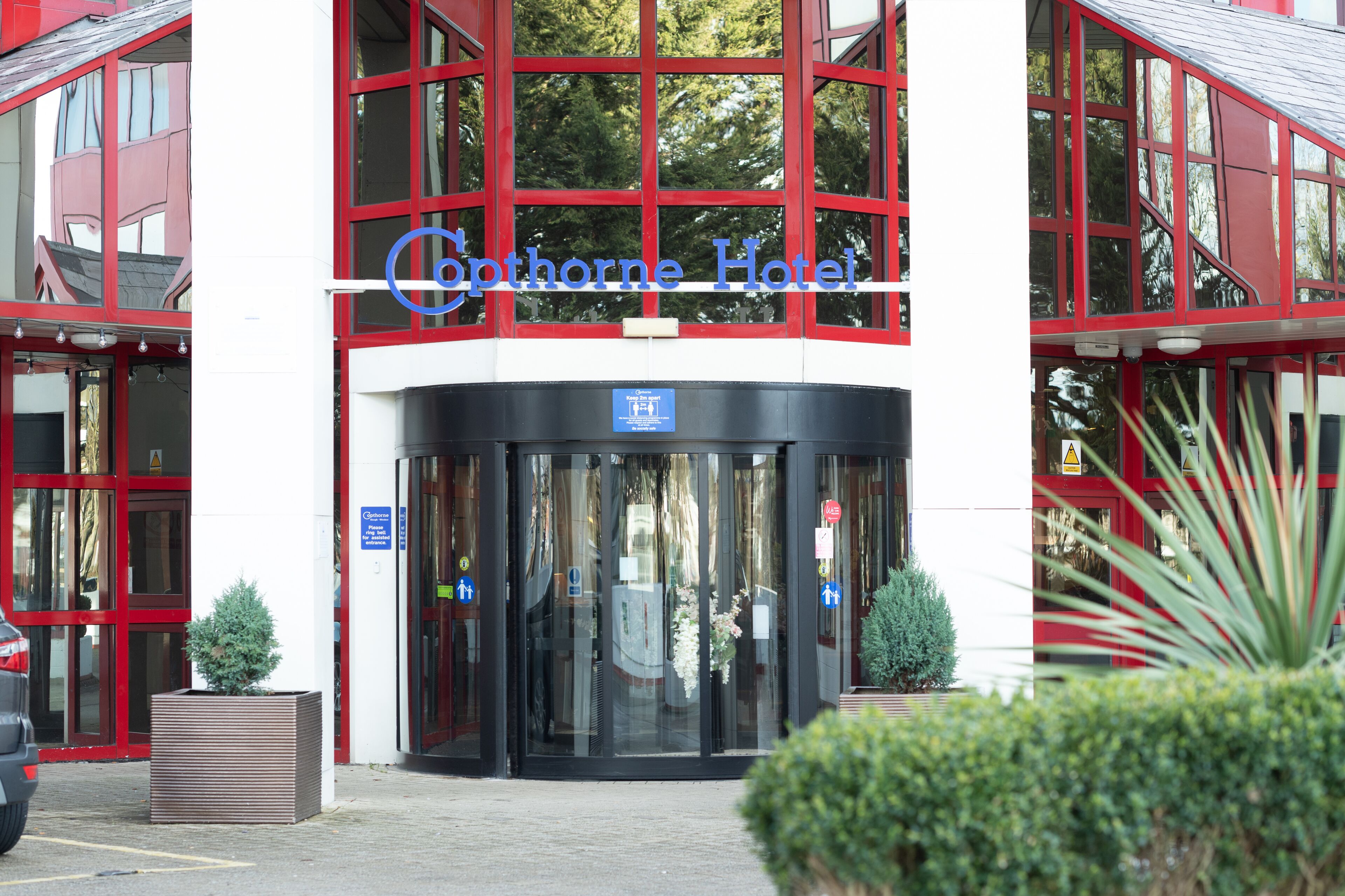 The entrance of the Copenhore Hotel with a revolving door and glass doors.