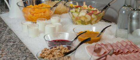 Una mesa de buffet con diversos alimentos y bebidas sobre hielo.