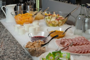 A buffet table with various food items and beverages on ice.