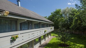 Un bâtiment à deux étages, doté d’un toit plat, de grandes fenêtres et d’une allée couverte agrémentée de plantes en pot.