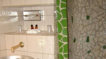 A bathroom with a sink, a mirror, and a towel rack.