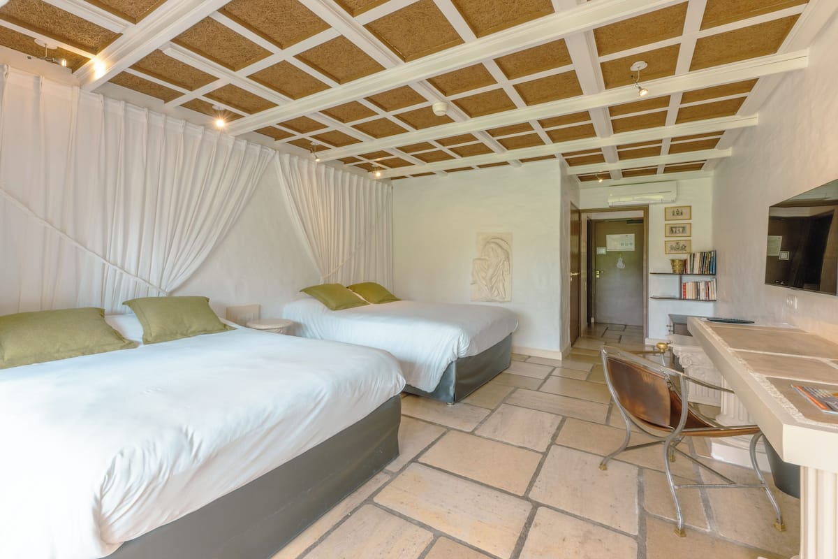 Ein Schlafzimmer mit zwei Betten, einem Schreibtisch und einem Stuhl.