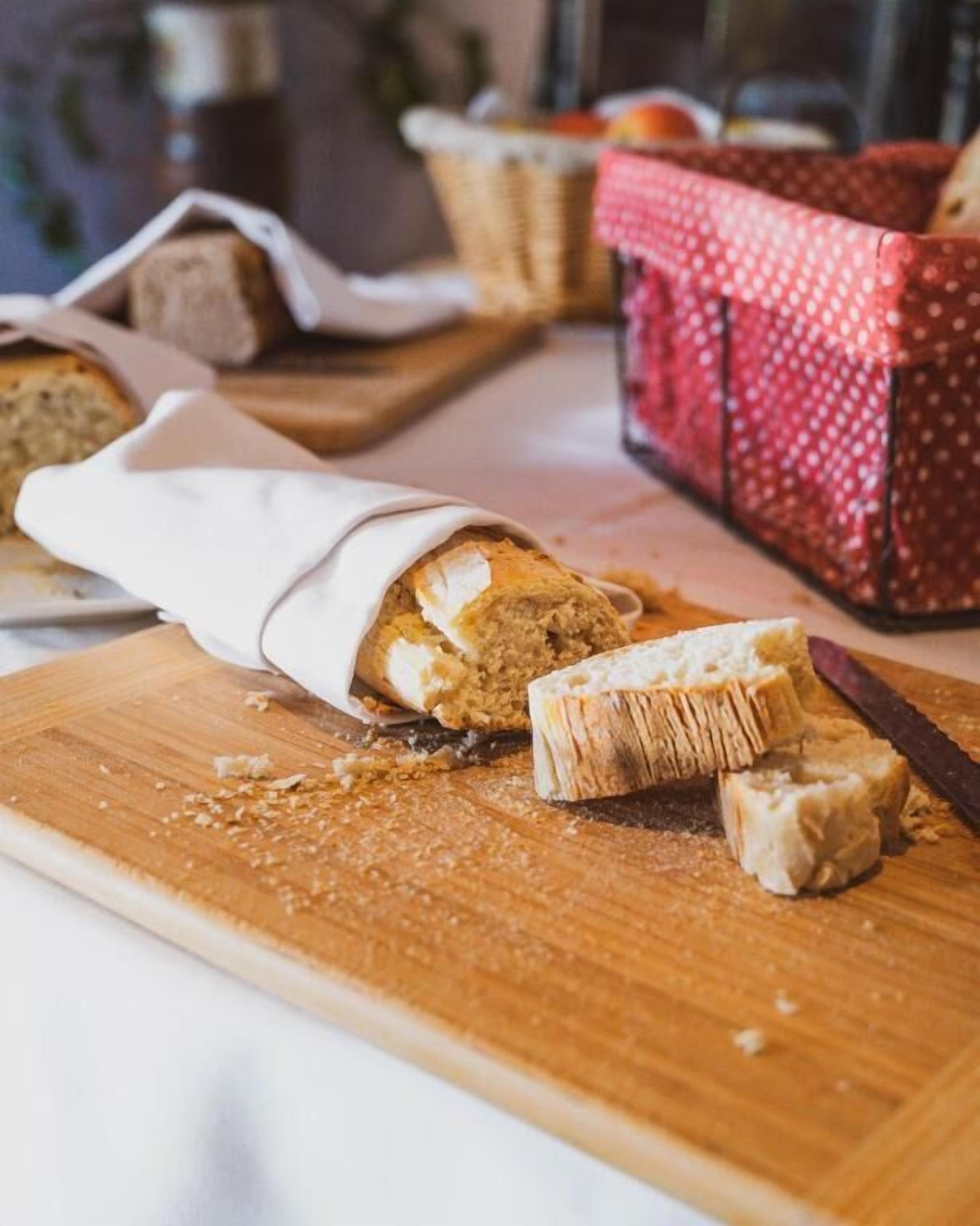 Una hogaza de pan sobre tabla de madera con un cuchillo y migas.