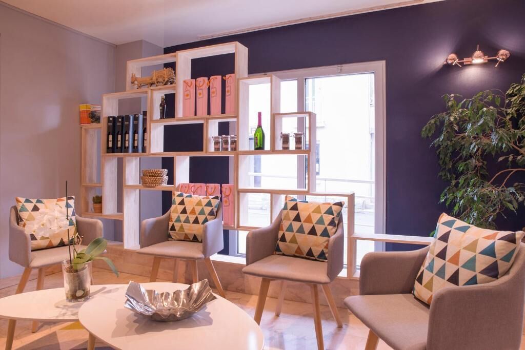 Una sala de estar moderna con un juego de sofá, una mesita de centro y una estantería con diversos objetos.
