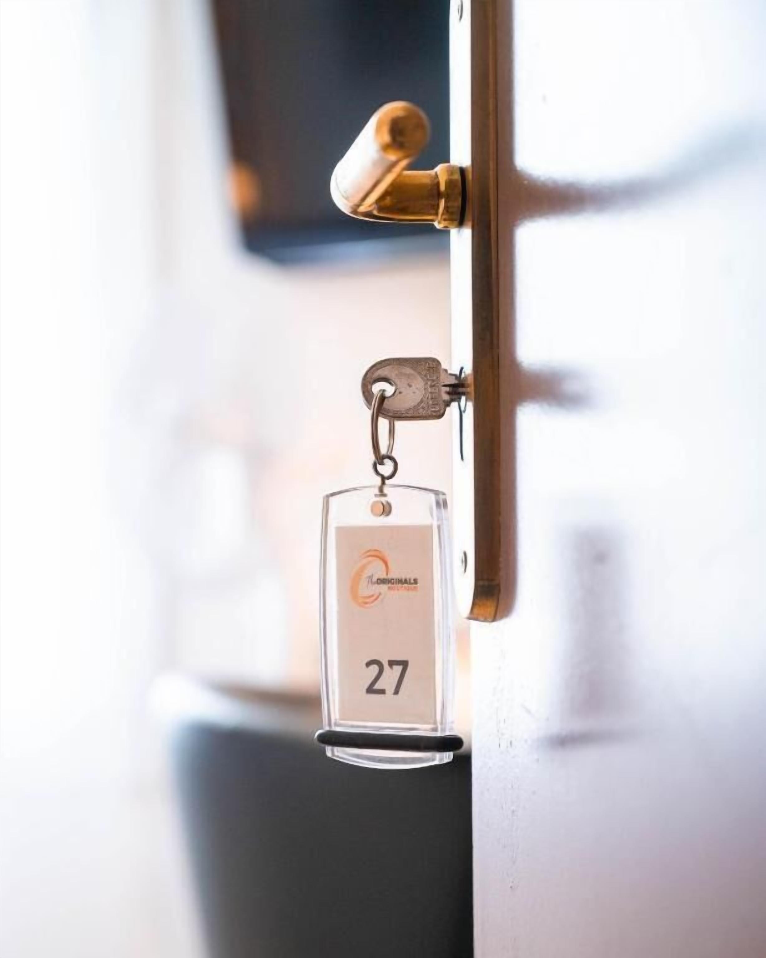 Un llavero con el nombre de un hotel y un número de habitación adjunto a una cerradura.