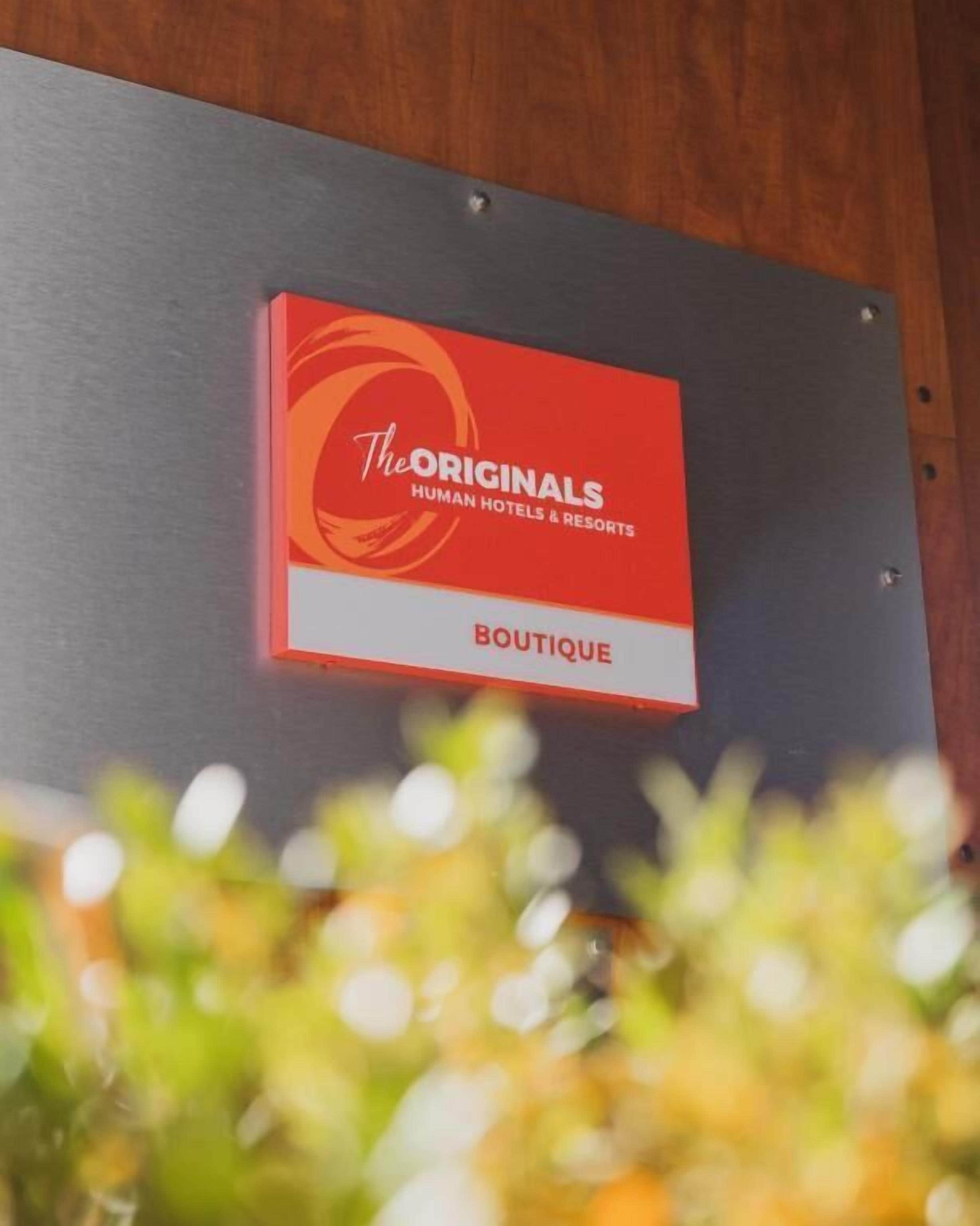 Letrero en una pared que dice 'The Originals Human Hotels & Resorts Boutique'.