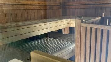 A sauna with wooden benches and a glass enclosure.