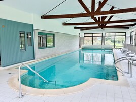 Una piscina cubierta, tumbonas