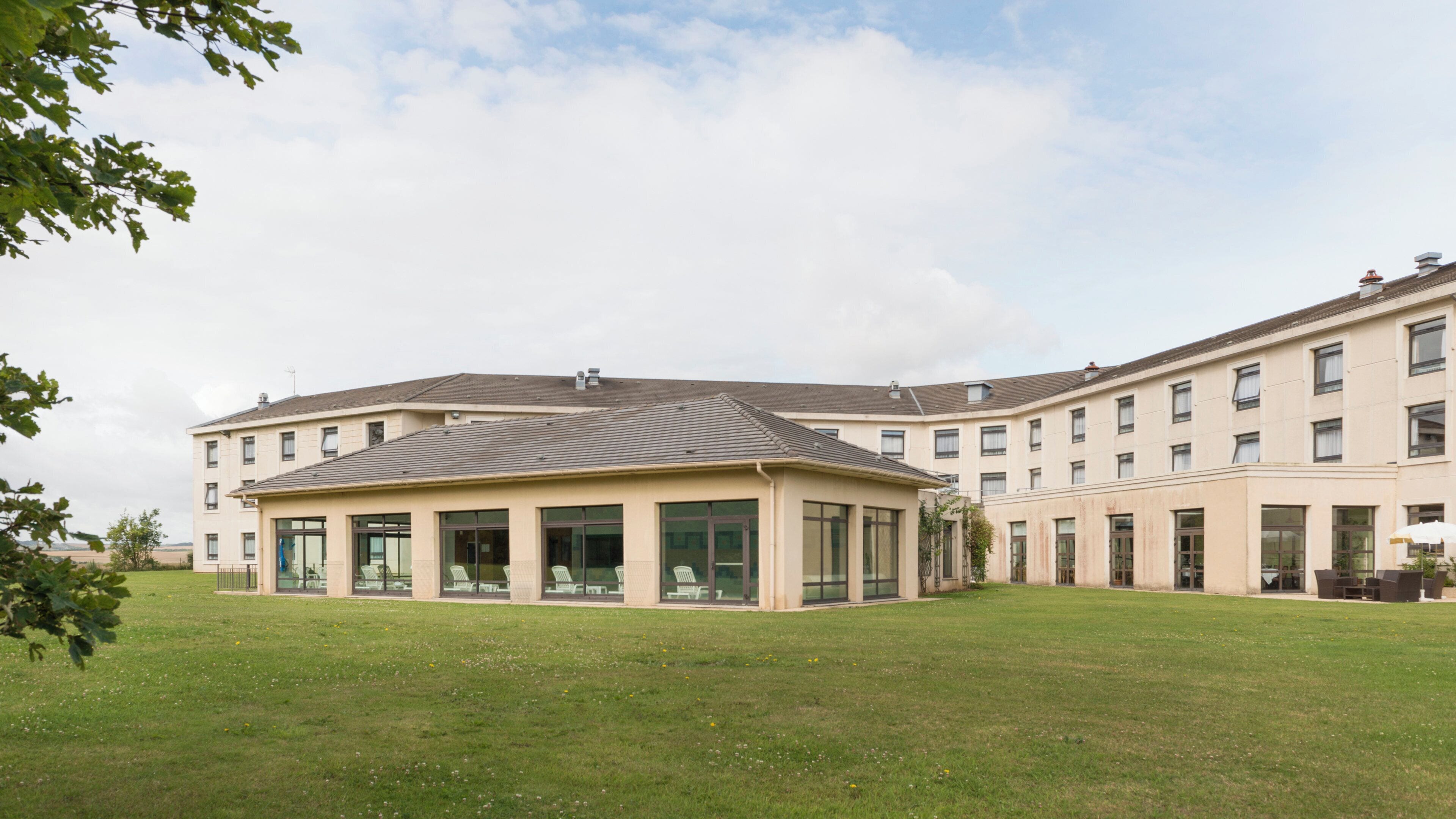 Un bâtiment moderne doté d ’un toit plat, de grandes fenêtres et d’une cour intérieure.