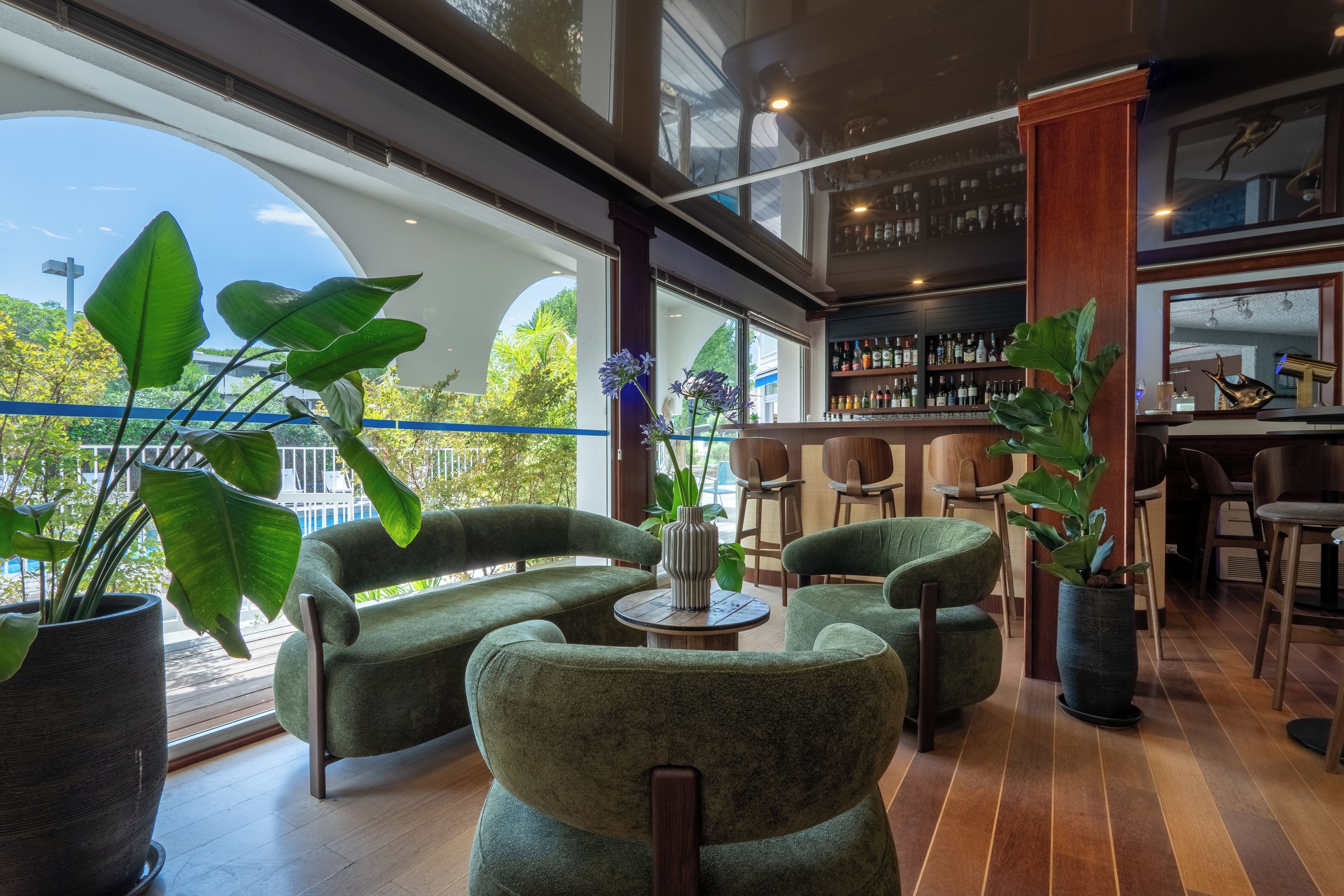 Un interior moderno con una zona de bar, asientos y ventanas amplias.