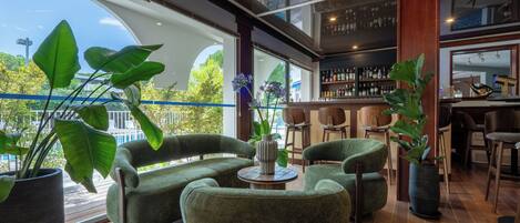 Un interior moderno con una zona de bar, asientos y ventanas amplias.